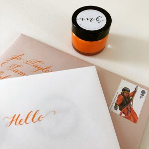 copperplate calligraphy writing in brilliant orange ink