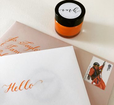 copperplate calligraphy writing in brilliant orange ink