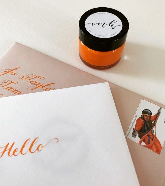 copperplate calligraphy writing in brilliant orange ink