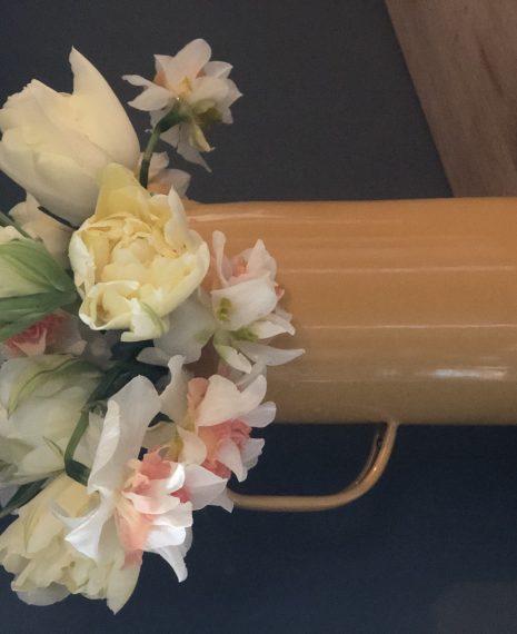 cut tulips in a mustard yellow tall vase