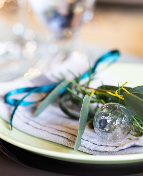 little glass bauble and evergreen foliage tied with a ribbon for a place setting