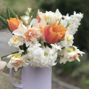 pael pink enamel jug with tulips and naricissi flowers in